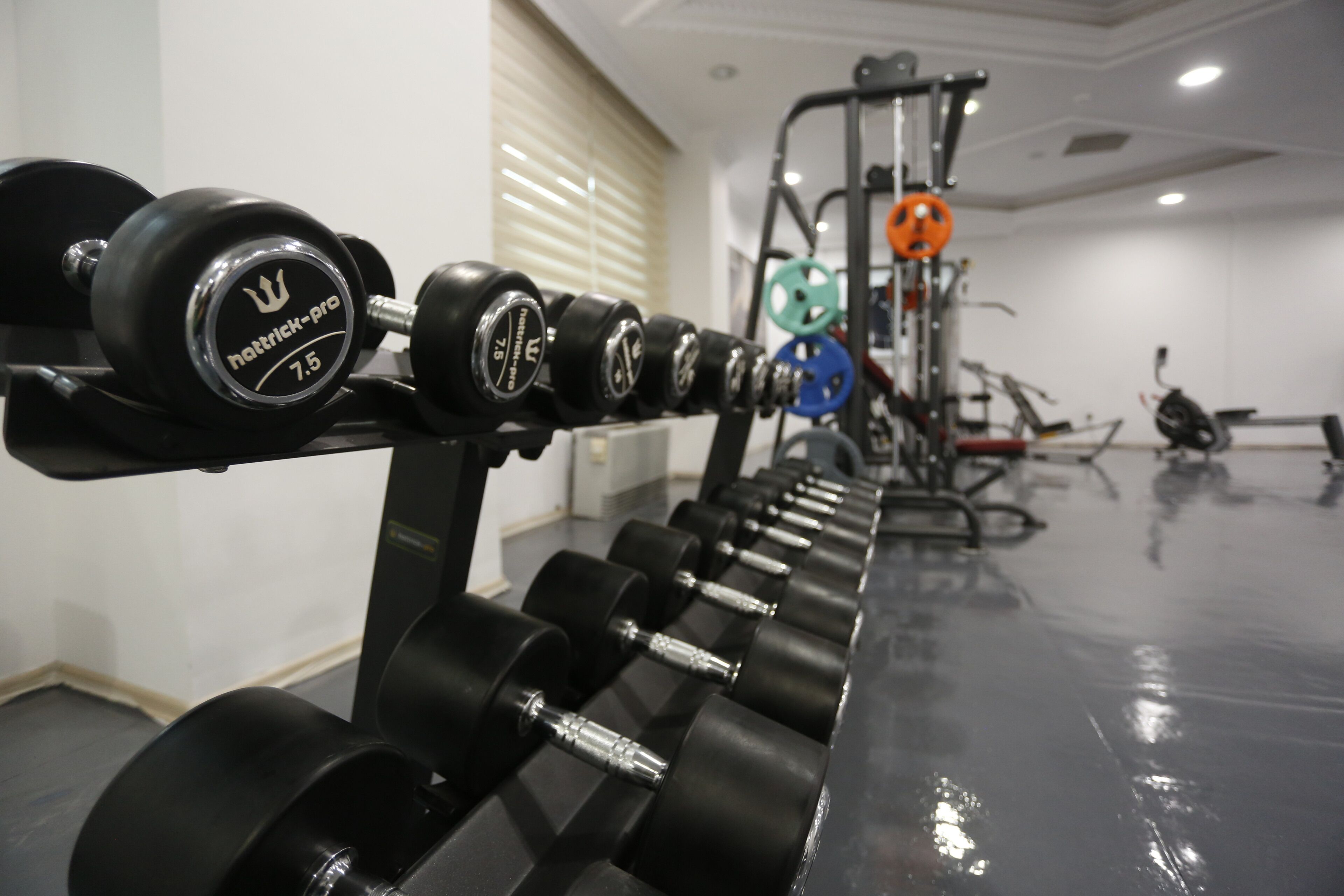 A gym with rows of dumbbells and weightlifting equipment.