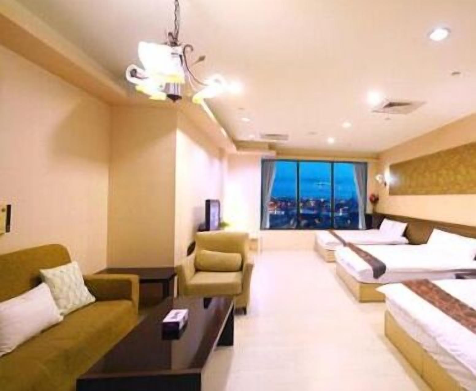 A hotel room with a bed, a sofa, a chair, and a desk.