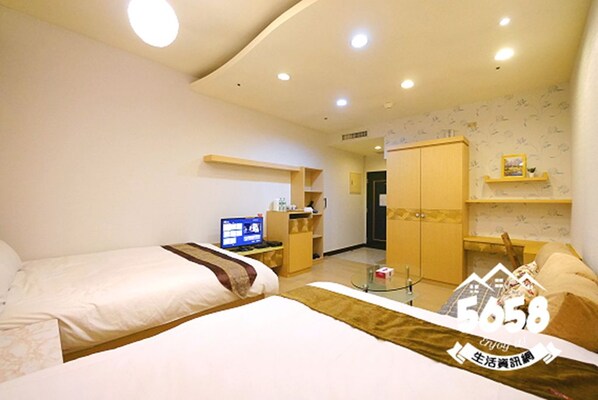 A hotel room with two beds, a desk with a computer, a wardrobe, and a small sitting area. - 85 Happy Holiday (Kaohsiung)