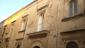 A historic building with arched windows, a balcony, and a door. - Palazzo Marturano (Lecce)