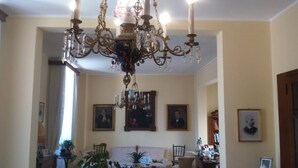 A living room with a chandelier, a sofa, chairs, and framed pictures on the wall. - Palazzo Marturano (Lecce)