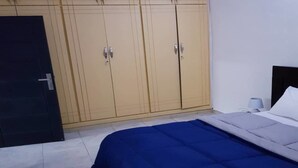 Ein Schlafzimmer mit einem Bett, einem Kleiderschrank und einer Tür.