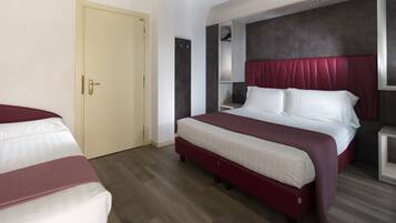 Una habitación de hotel con una cama grande, un armario y una puerta.