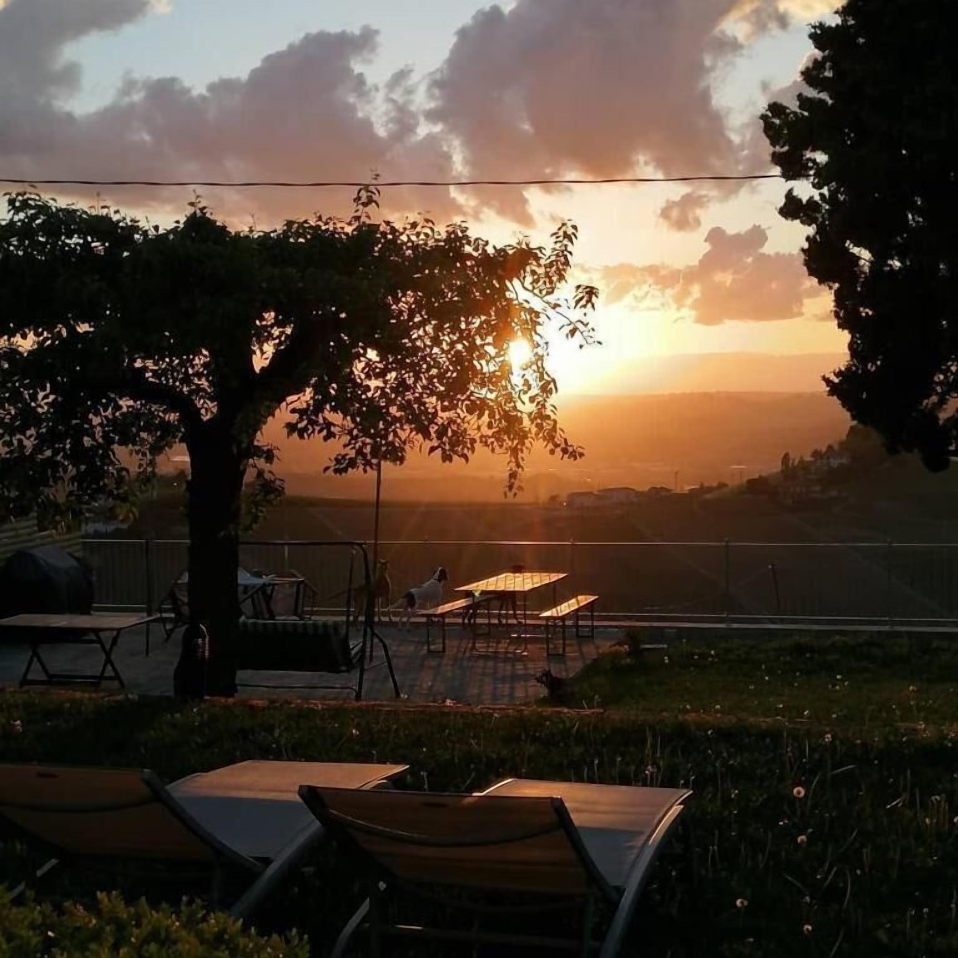 Vista del atardecer con un área de comedor que incluye mesas y sillas.