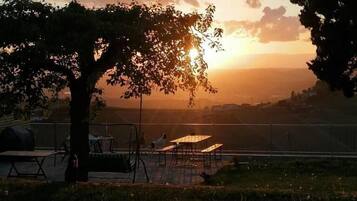 Vista del atardecer con un área de comedor que incluye mesas y sillas.