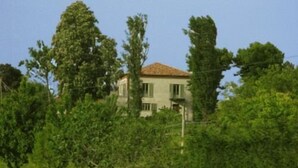 A house surrounded by trees and a wooden fence. - Casa Vacanze San Stefanetto (Treiso)