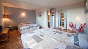 A hotel room with two beds, a desk, a chair, and a small table. - La Grange de Marie (Nitry)