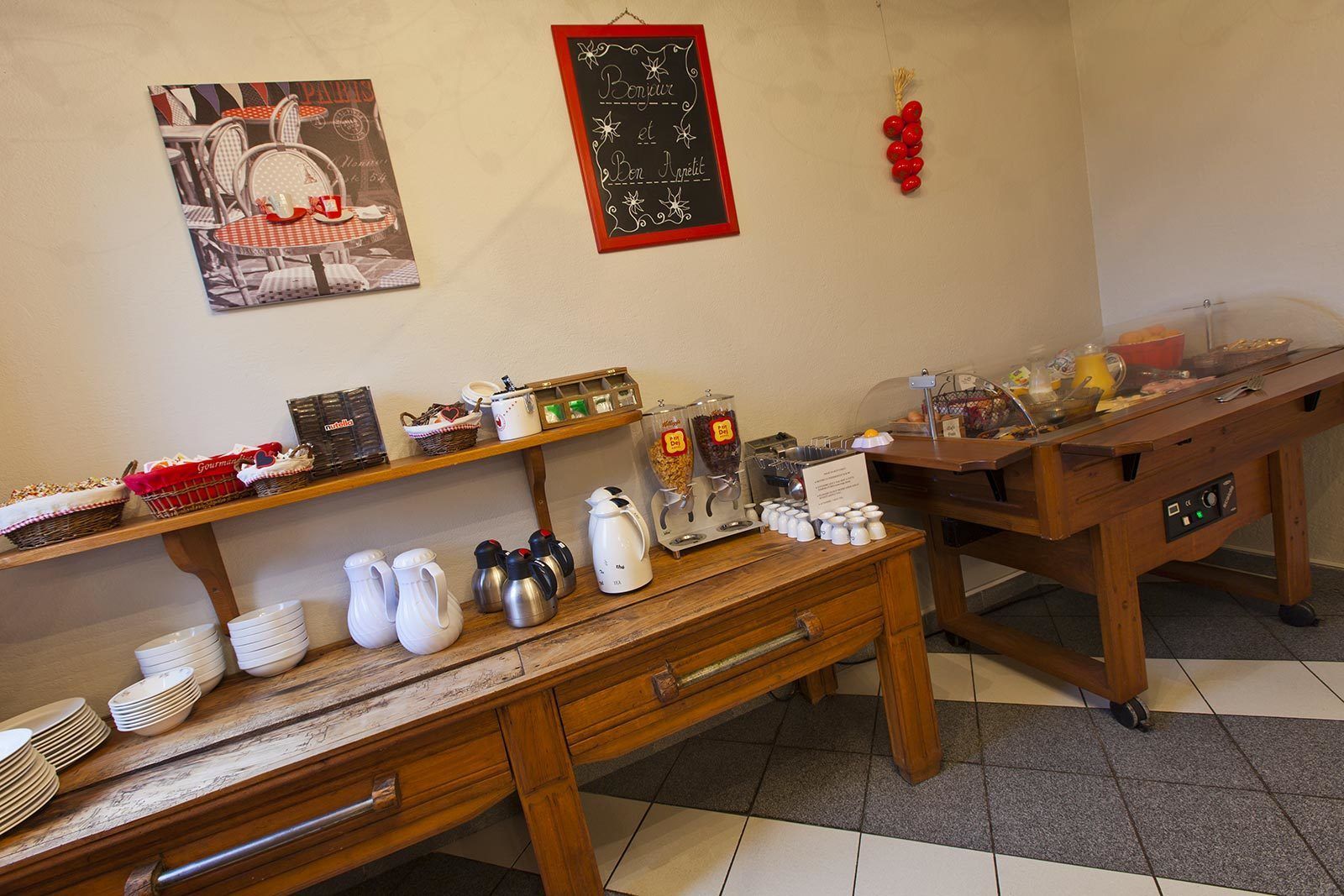 Una mesa de madera con cafeteras y un cartel en una pizarra.