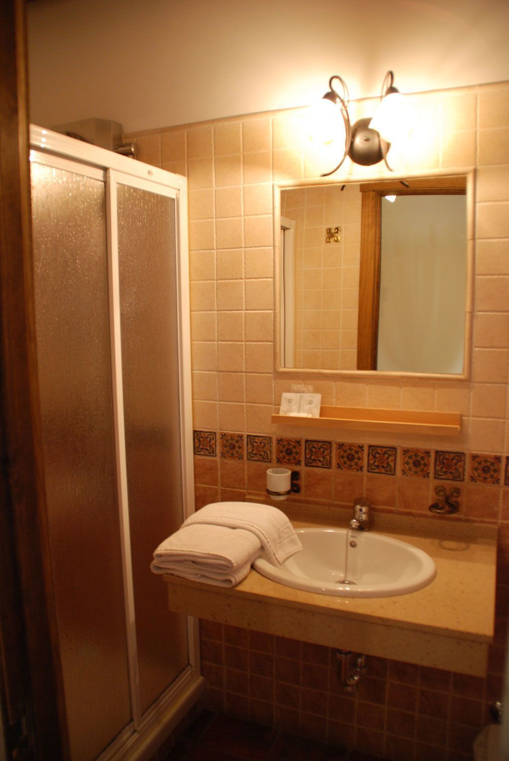 A bathroom with a shower, a sink, and a mirror.