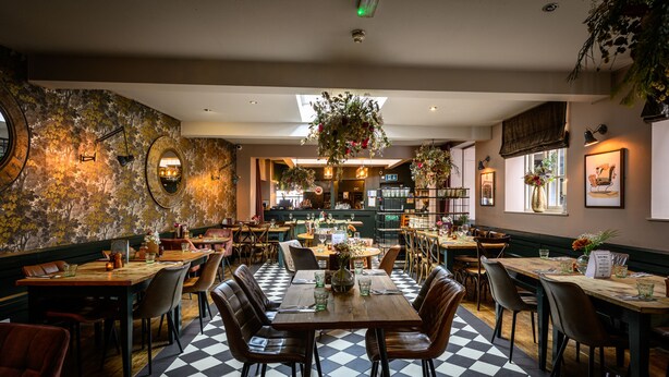 A restaurant with a checkered floor, wooden tables, and chairs. - The Loopy Shrew (Shrewsbury)