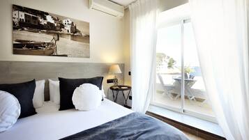 Habitación de hotel con una cama grande, vista al exterior y un cuadro en la pared.