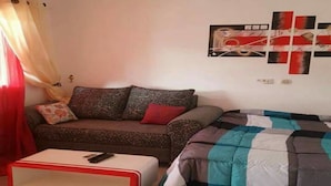 A living room with a sofa, a coffee table, and a wall with artwork. - Les Residences Rima 9 (Abidjan)