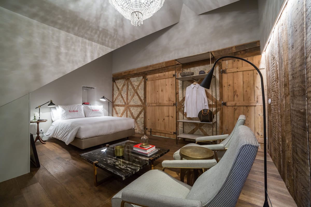 Une pièce confortable avec un lit, un canapé, une table basse et une armoire en bois.