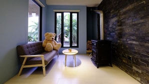 A cozy living room with a sofa, a round table, a teddy bear, and a fireplace. - Take Sunny B&B (Shoufeng)