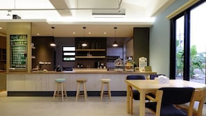 A cafe with a counter, stools, and a table with chairs. - Take Sunny B&B (Shoufeng)