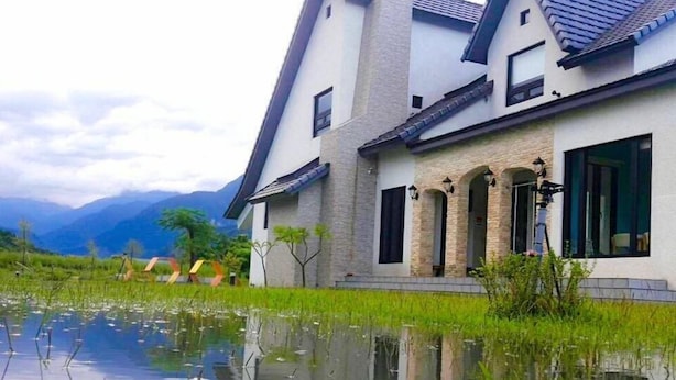 A modern house with a large water feature in front. - Take Sunny B&B (Shoufeng)