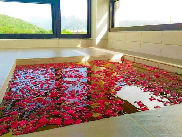 A room with a large window, a tiled floor, and a bench.