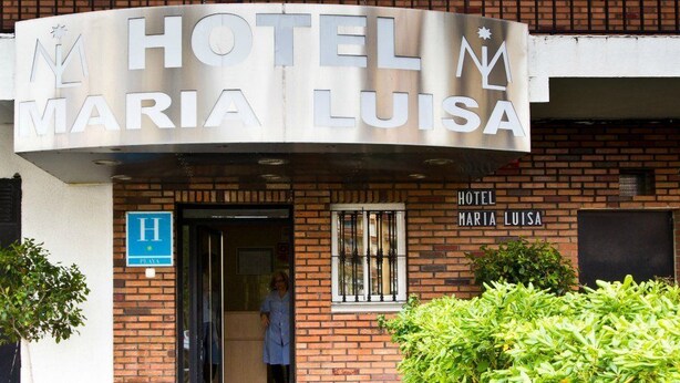 The exterior of Hotel Maria Luisa with a prominent sign, a blue handicap accessibility sign, and a person standing at the entrance. - Hotel María Luisa (Algeciras)