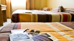 A hotel room with a bed, a bedside table, and a blanket. - Hotel María Luisa (Algeciras)