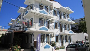 A multi-story hotel with balconies, a staircase, and a sign indicating it is a hotel. - Vural Apart Hotel (Cesme)