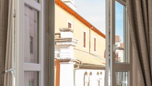 Una ventana con vista a un edificio de techo puntiagudo y campanario.