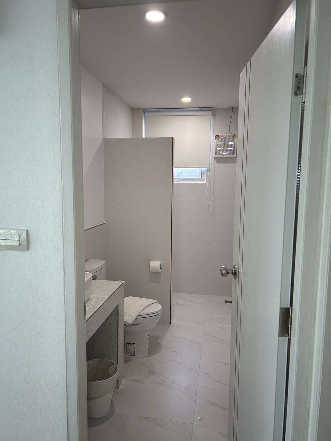 A compact bathroom with a toilet, sink, and a small window.