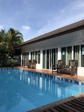 Una piscina al aire libre, sombrillas