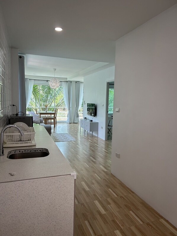 Una cocina moderna con un lavamanos, un escurreplatos y una zona de comedor con una mesa y sillas.