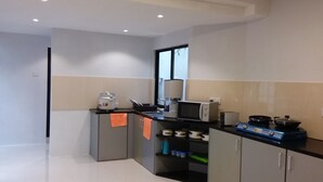 A compact kitchen with a microwave, stove, and storage cabinets. - Colombo Residence - Luxury House - B & B (Colombo)