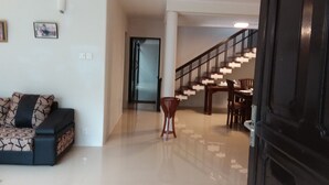 A modern living room with a sofa, a dining table, and a staircase. - Colombo Residence - Luxury House - B & B (Colombo)