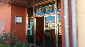 A hotel entrance with a glass door, red chairs outside, and a sign reading "HOTEL PIO XII". - Hotel Pio XII Jumilla (Jumilla)