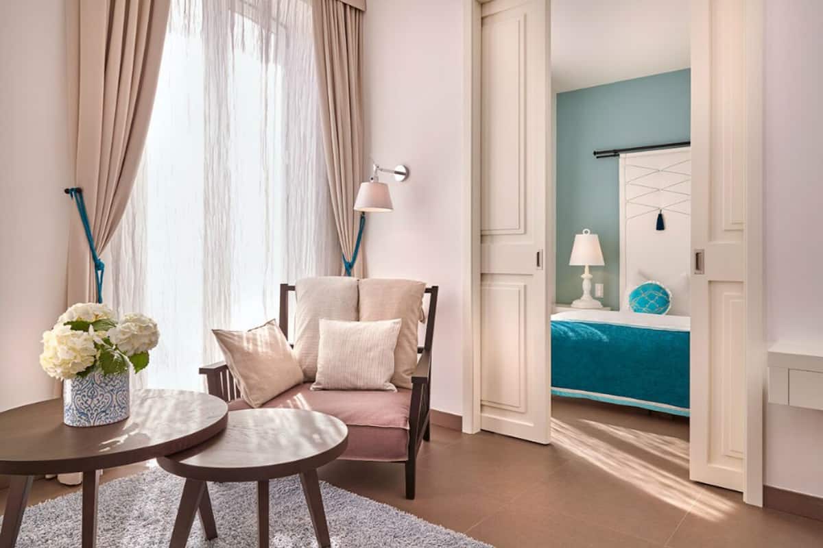 Een hotelkamer met een bed, een stoel, een tafel en een lamp.