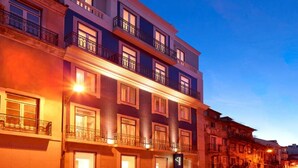 Un hôtel à plusieurs étages, doté de balcons et de fenêtres illuminées.