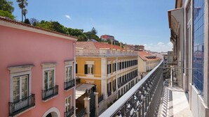 Une rue étroite, bordée de bâtiments des deux côtés, avec des balcons et un ciel dégagé.