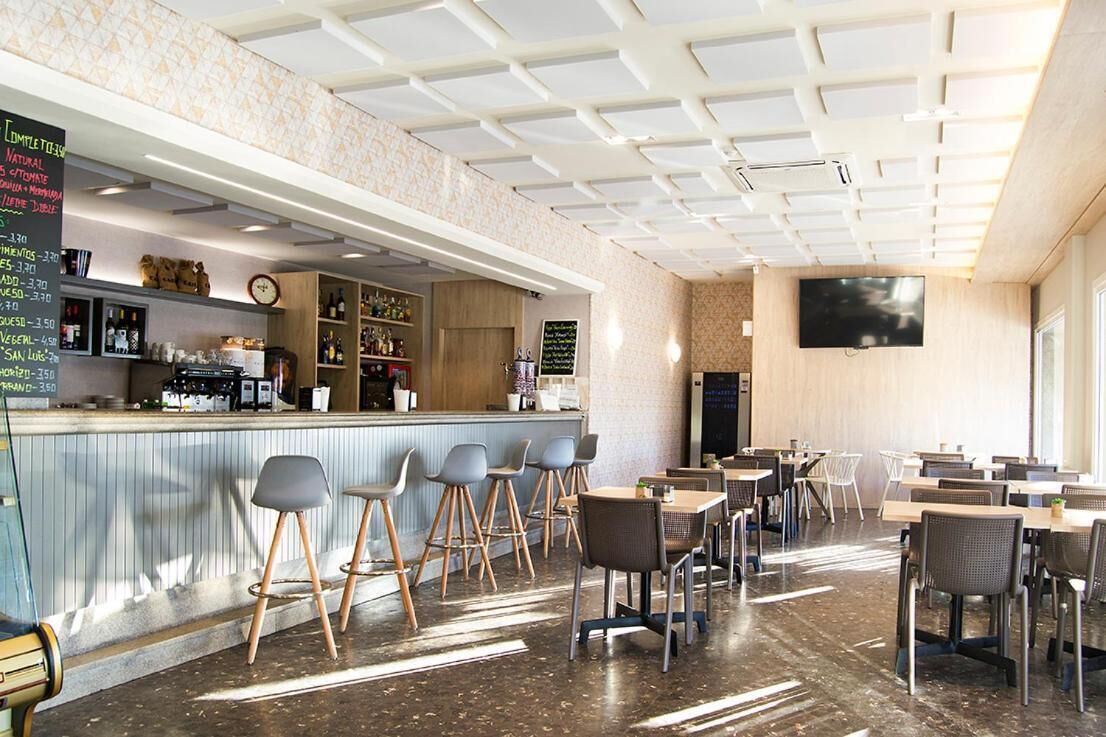 Un café moderne doté d’un bar, de tables et d’un écran de télévision.
