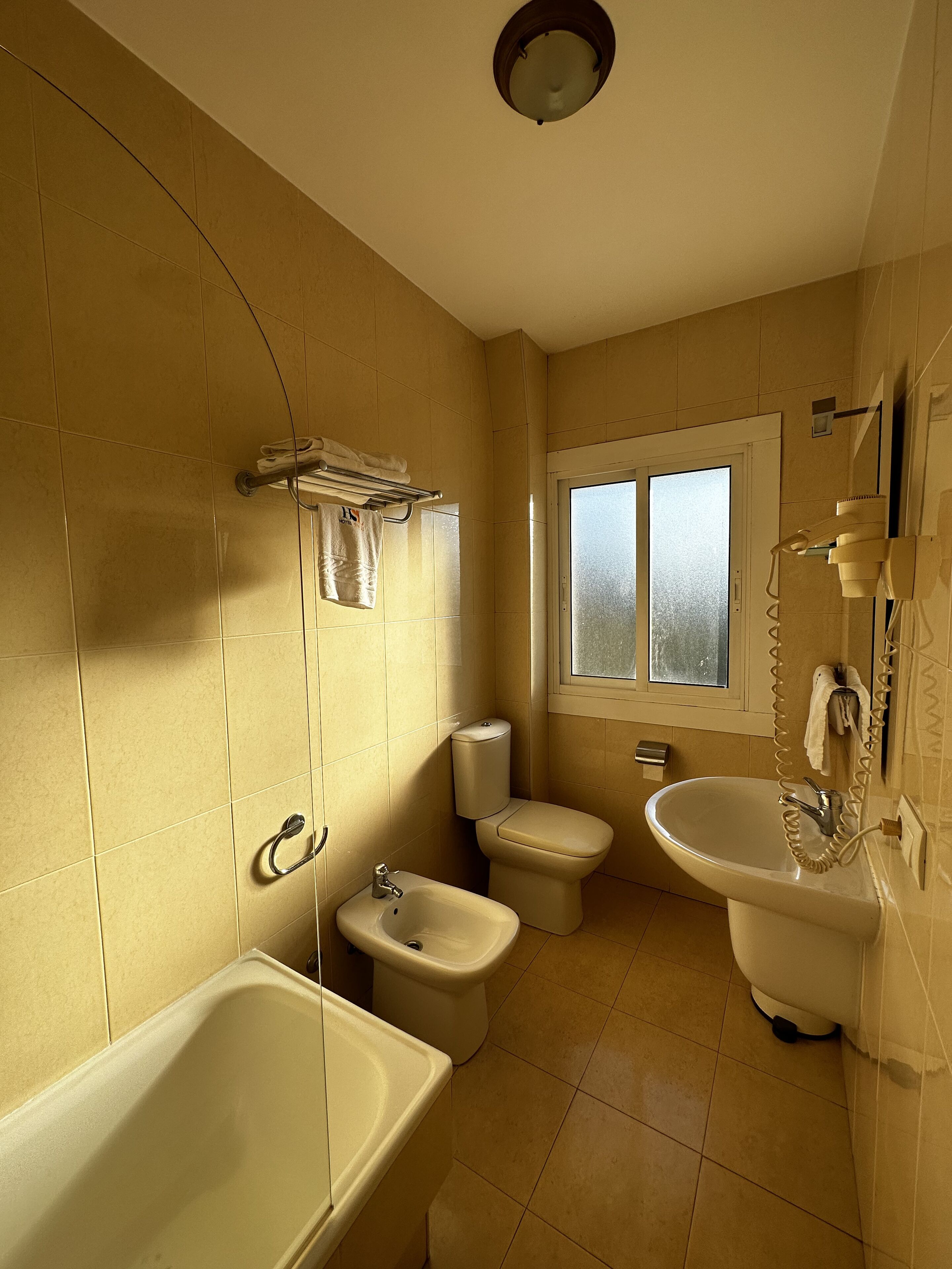 A bathroom with a bathtub, a sink, a toilet, and a bidet.