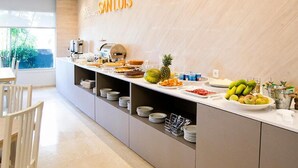 A breakfast buffet with various food items and a coffee machine.