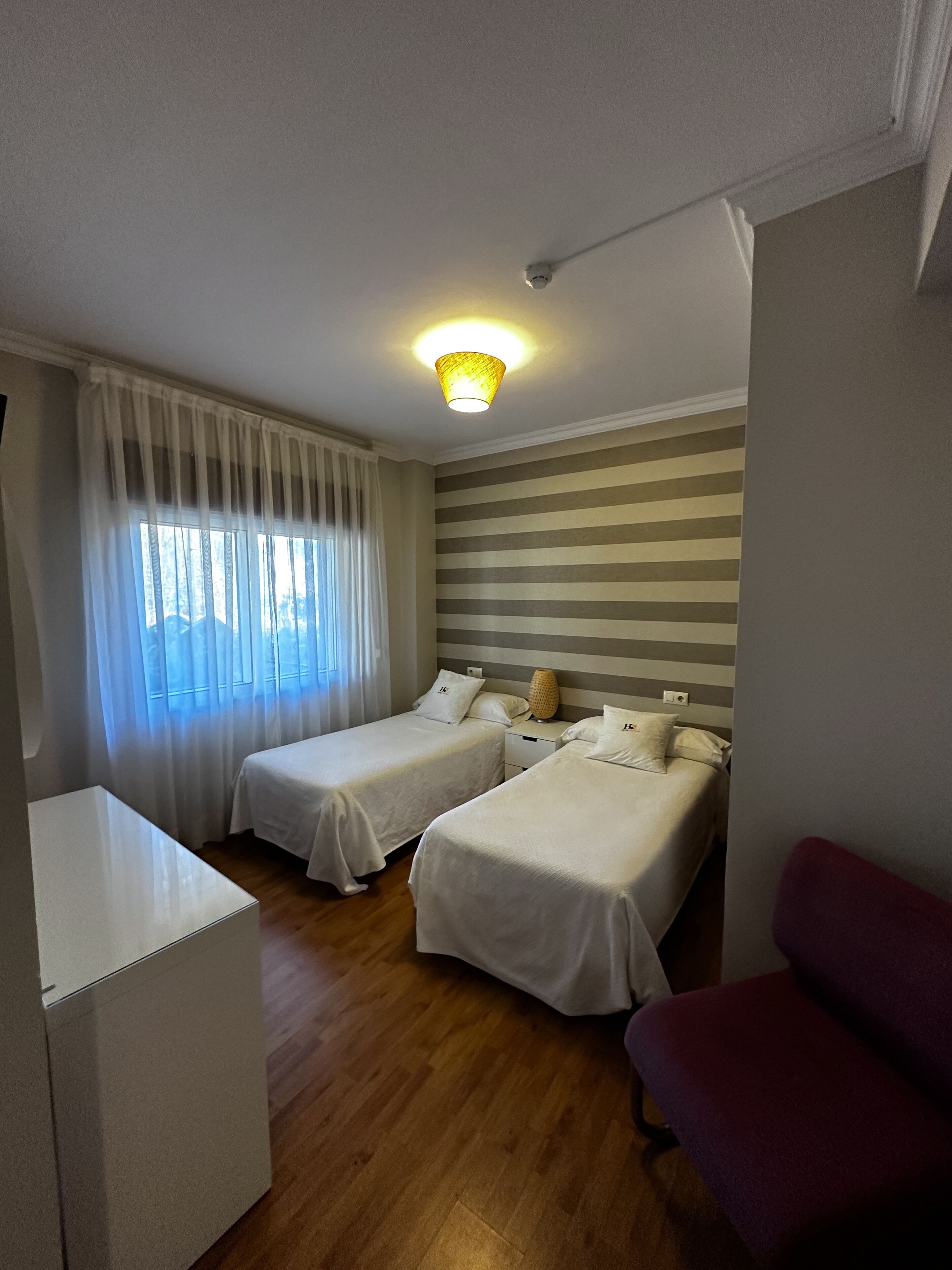 Een kamer met twee bedden, een bureau en een stoel.