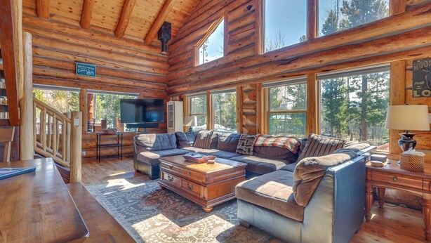 A log cabin interior with a large sofa, wooden coffee table, and a TV in the corner. - Access to Rocky Mtn Nat'l Park: Grand Lake Cabin (Grand Lake)