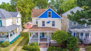 A two-story house with a blue roof and a porch. - Coastal Charmer, Fire Pit & Two Blocks to Beach (Cape Charles)