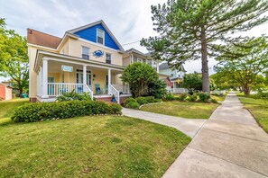 A two-story house with a porch, a blue roof, and a sign that reads "Cozy Corner." - Coastal Charmer, Fire Pit & Two Blocks to Beach (Cape Charles)