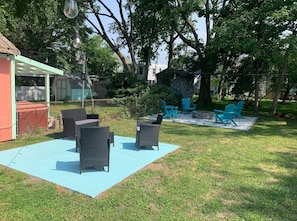 A backyard with outdoor furniture, a stone fire pit, and a pergola. - Coastal Charmer, Fire Pit & Two Blocks to Beach (Cape Charles)
