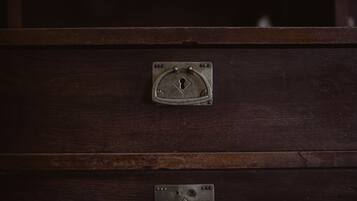 A dark wooden cabinet with a metal latch and a keyhole.