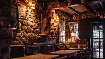A rustic interior with stone walls, wooden furniture, and vintage decor.