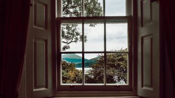An open window with a view of trees and hills.