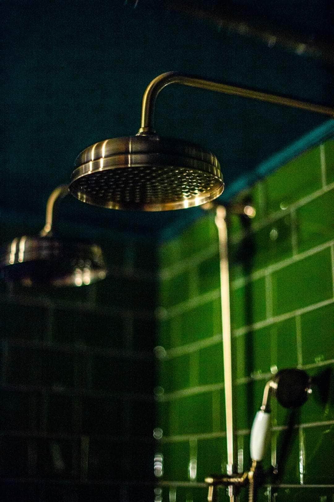 A shower with a curved head and a metallic finish.