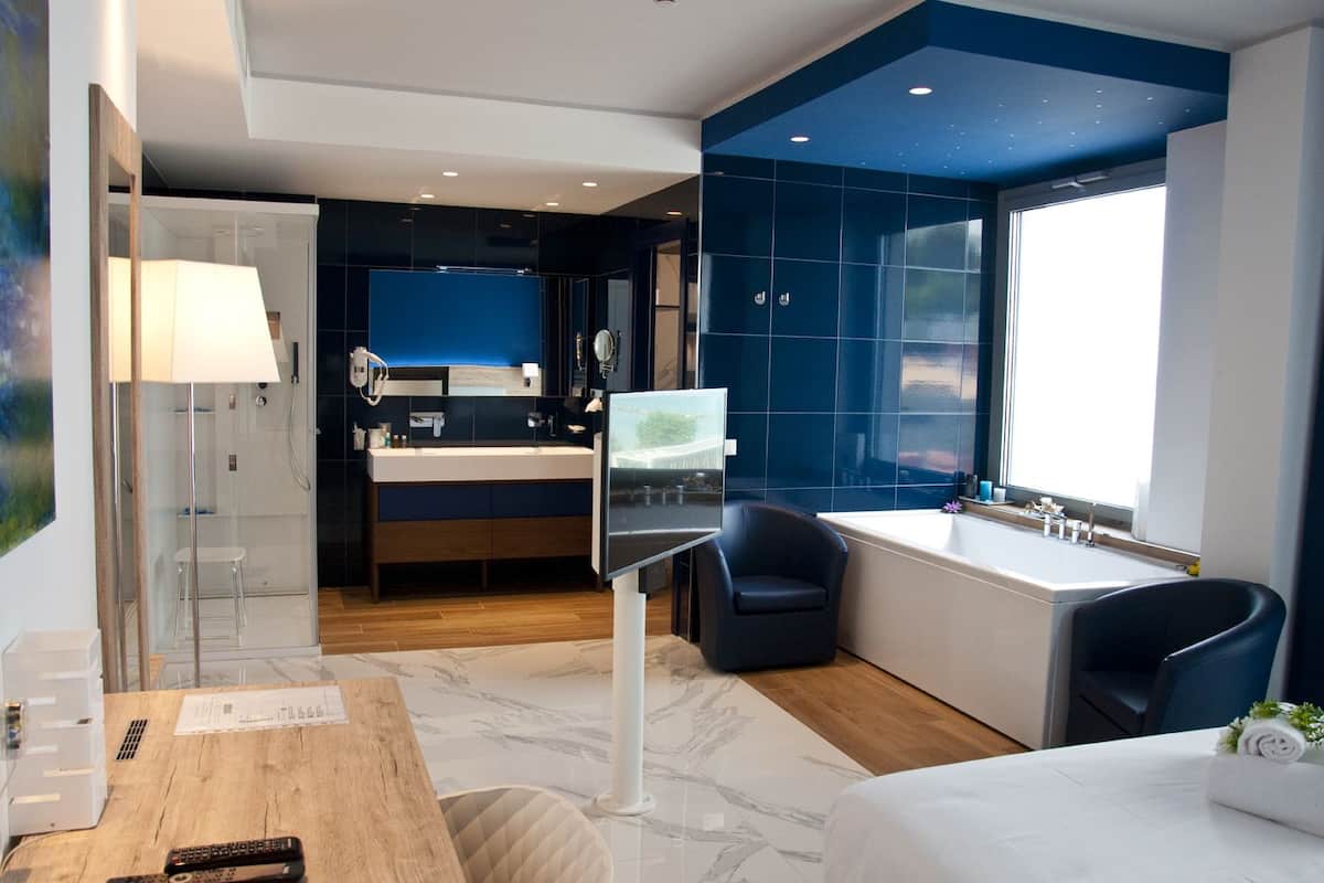 Een moderne badkamer met een grote spiegel, een bad en een douche.