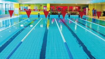 Una piscina interior con múltiples carriles, delimitados por separadores.