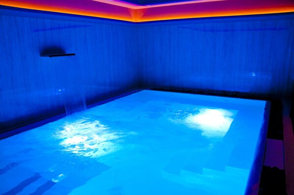 A room with a blue-lit jacuzzi. - Ambruosi Village Resort & Spa (Massignano)