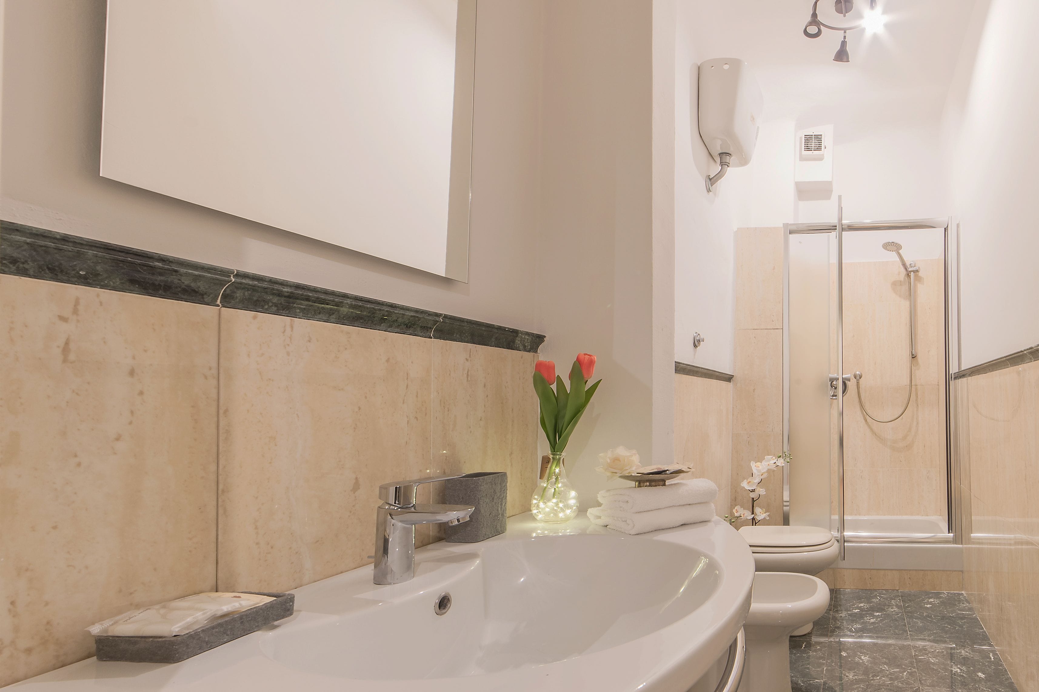 A modern bathroom with a large sink, toilet, and shower area.